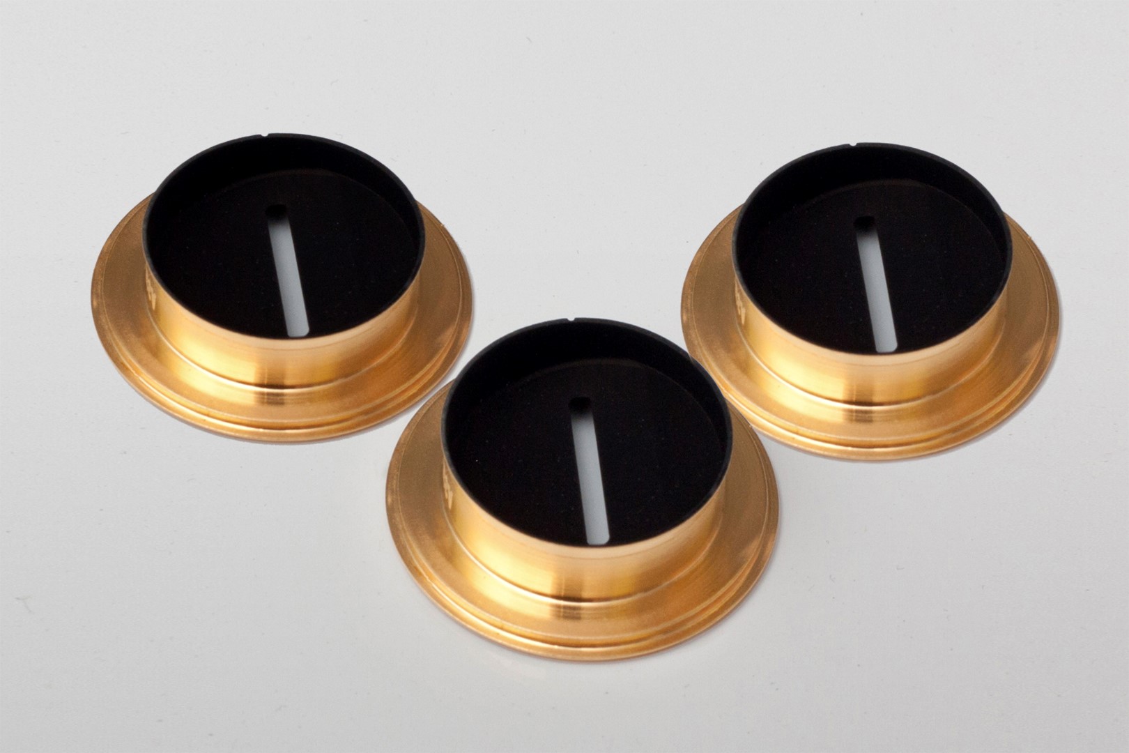 3 metallic circular components coated with acktar's magic black coating